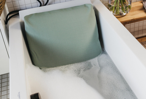 Badewannenkissen in befüllter Badewanne.