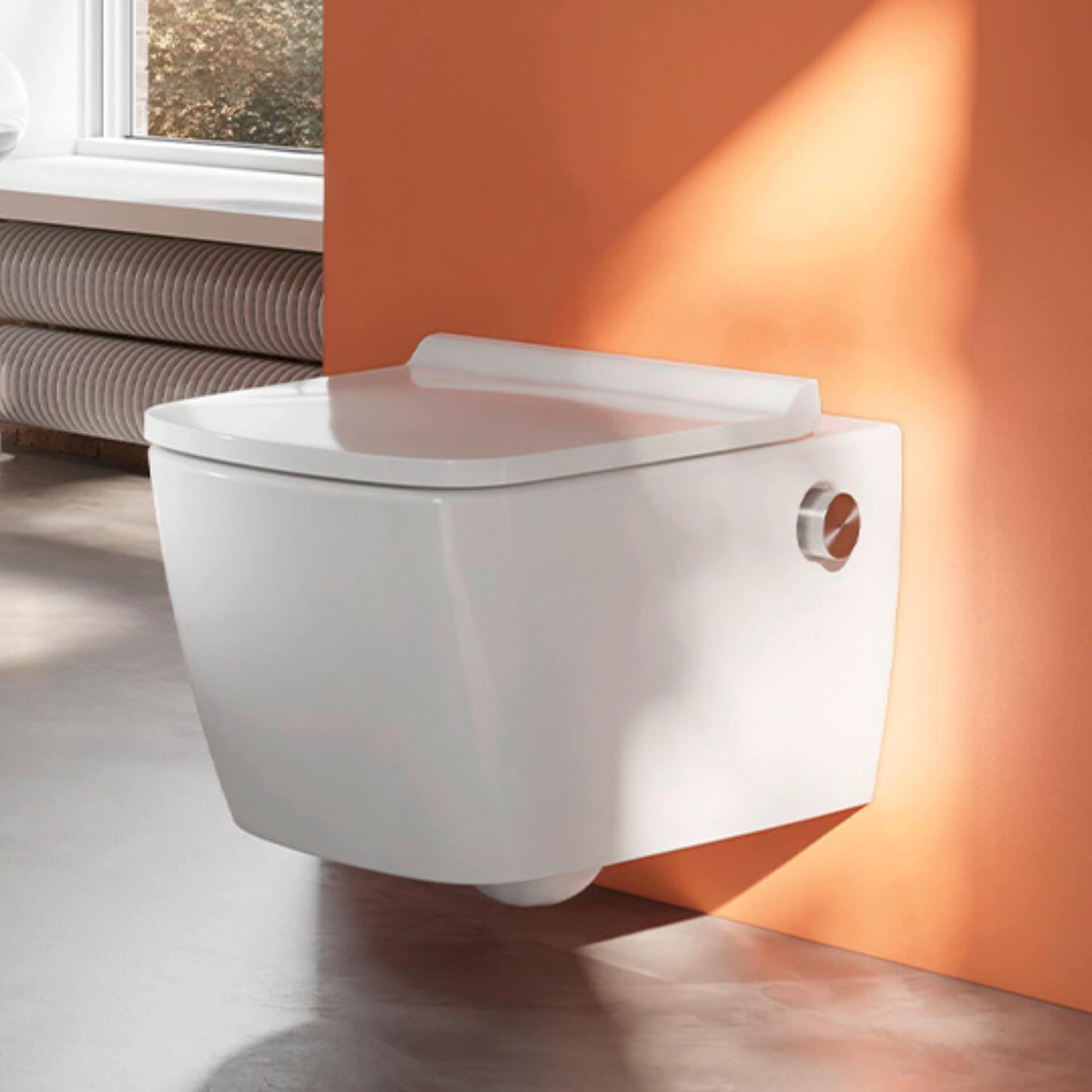 TECE Toilette an orangener Wand.