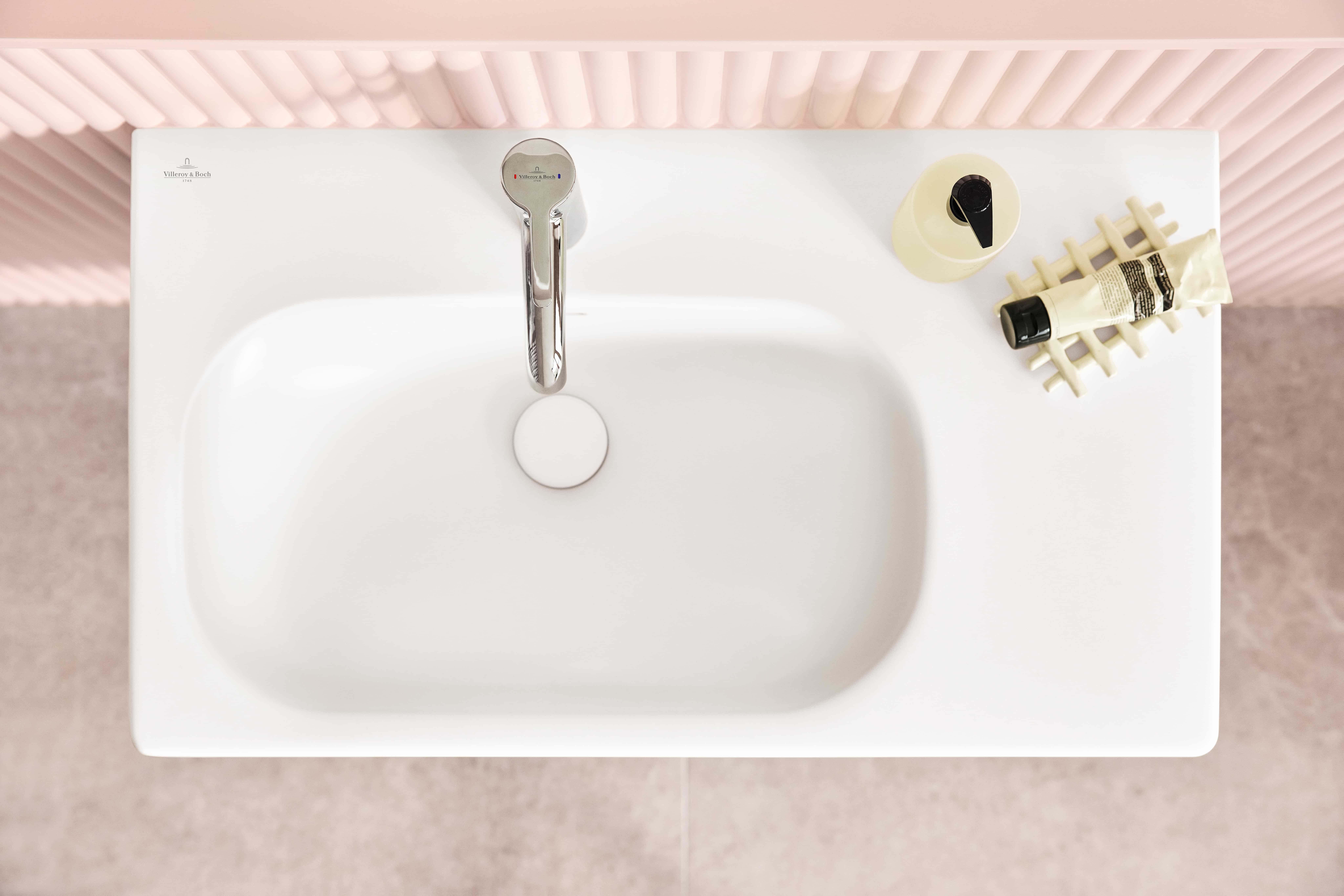 Asymmetrisches Waschbecken mit Ablagefläche rechts.