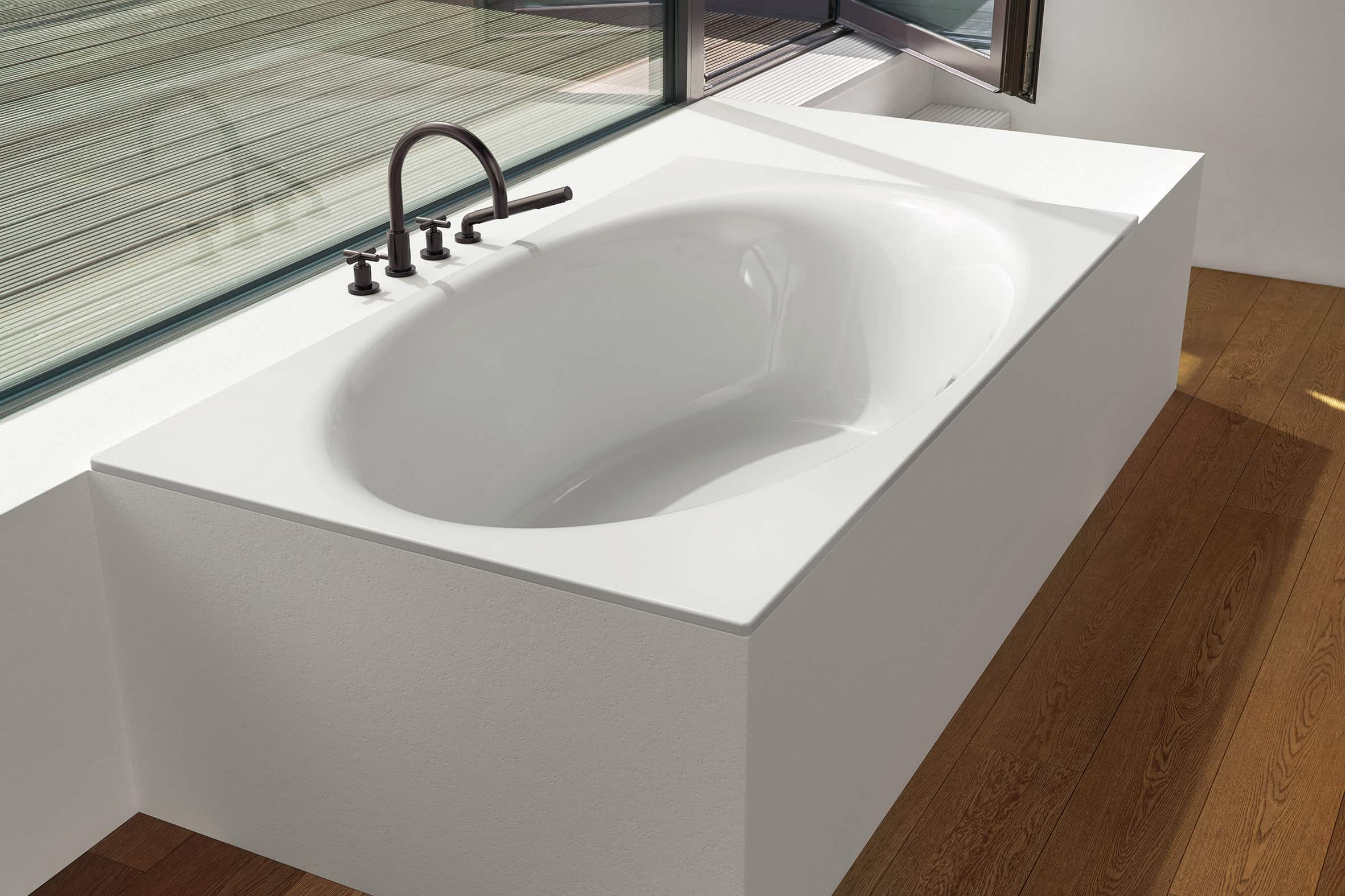 Ovale Doppelbadewanne mit schwarzer Armatur.