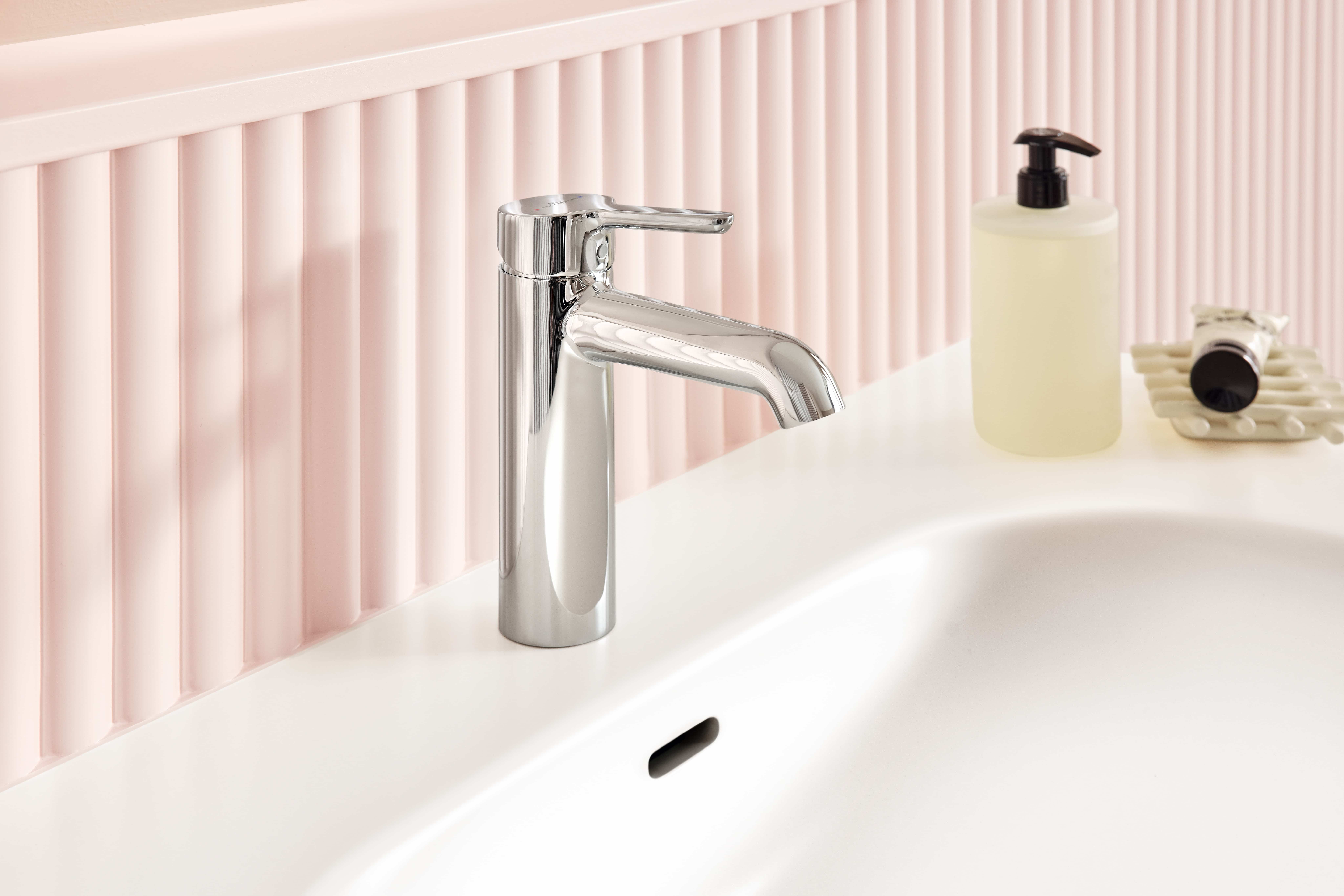 Verchromte Einhebel-Armatur am weißen Waschbecken vor rosa W