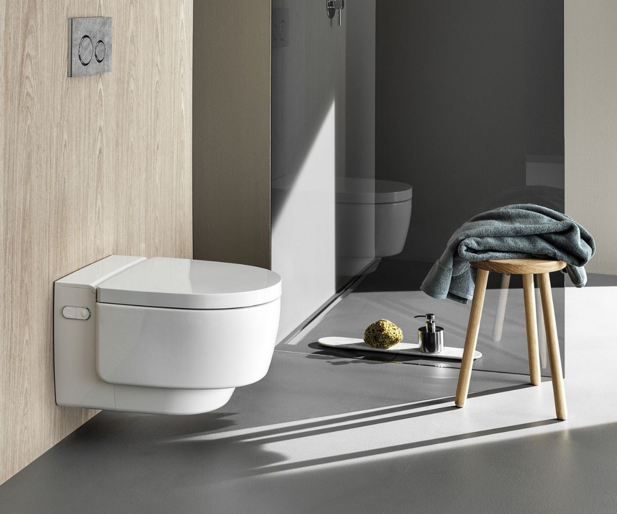Dusch-WC mit einem Hocker daneben.