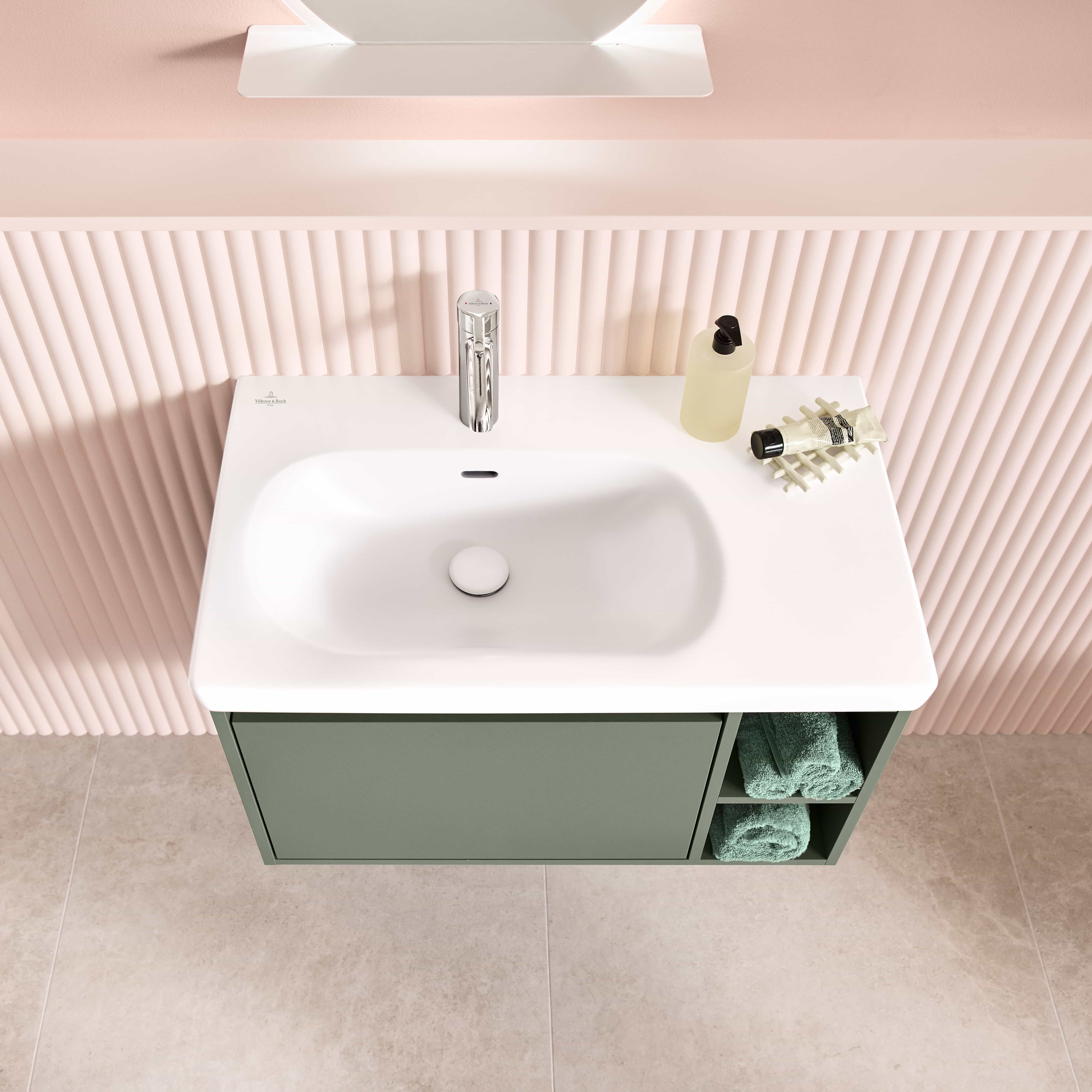 Asymmetrisches Waschbecken mit Ablagefläche rechts.