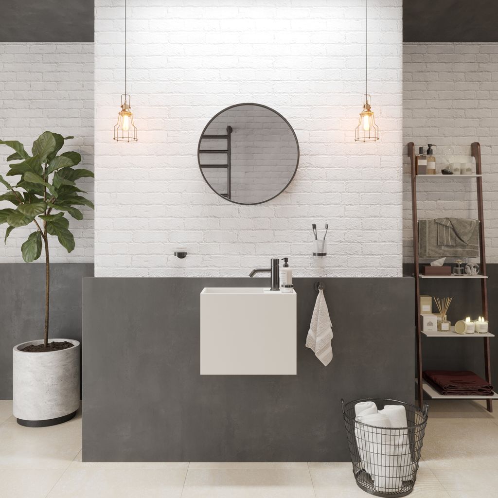 Badezimmer mit rundem Spiegel, Waschbecken und Pflanzen