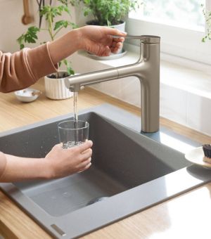 Kuechen-Einhebelmischer mit dem ein Glas mit Wasser befüllt wird.
