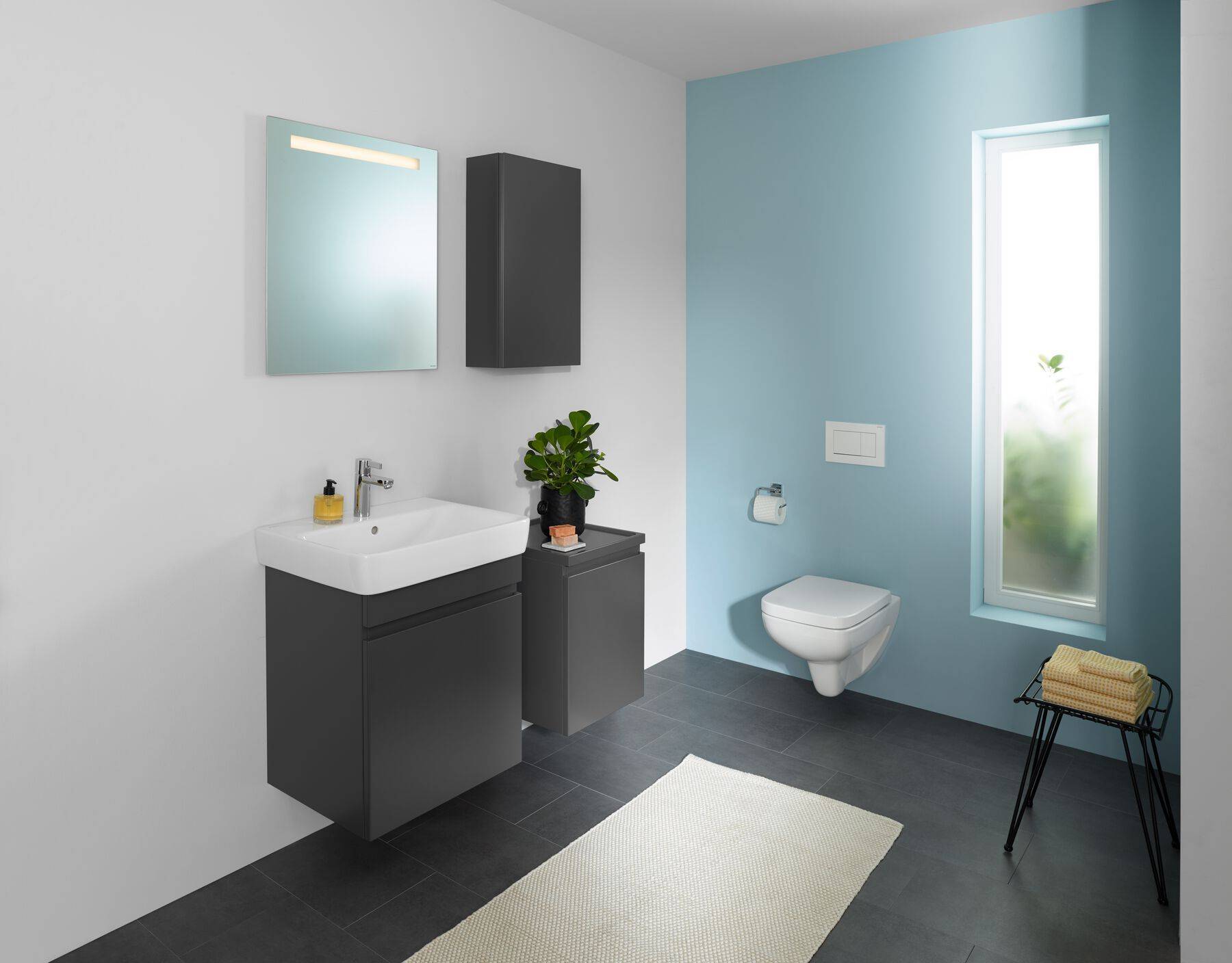 Badezimmer mit Waschbecken, Spiegel, Hängeschrank und Wand-W