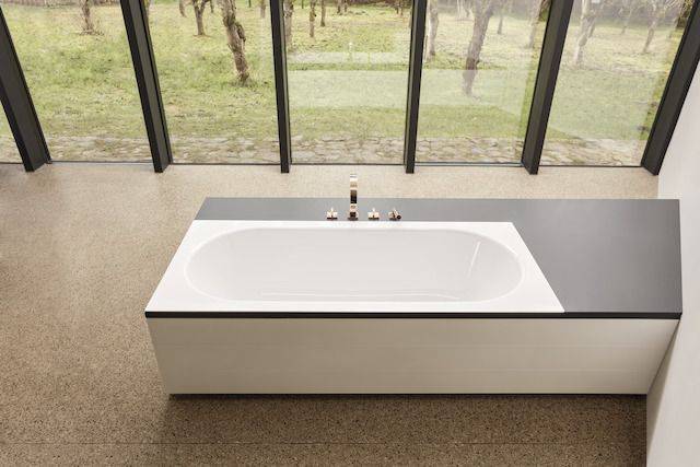 Moderne Doppelbadewanne vor Fensterfront.